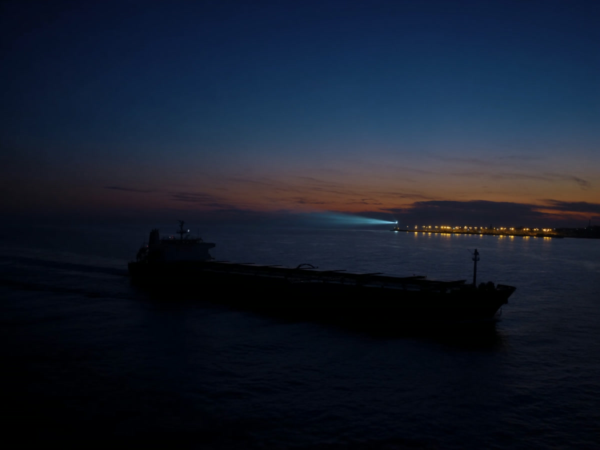 Navio de carga partindo em direção ao horizonte ao entardecer